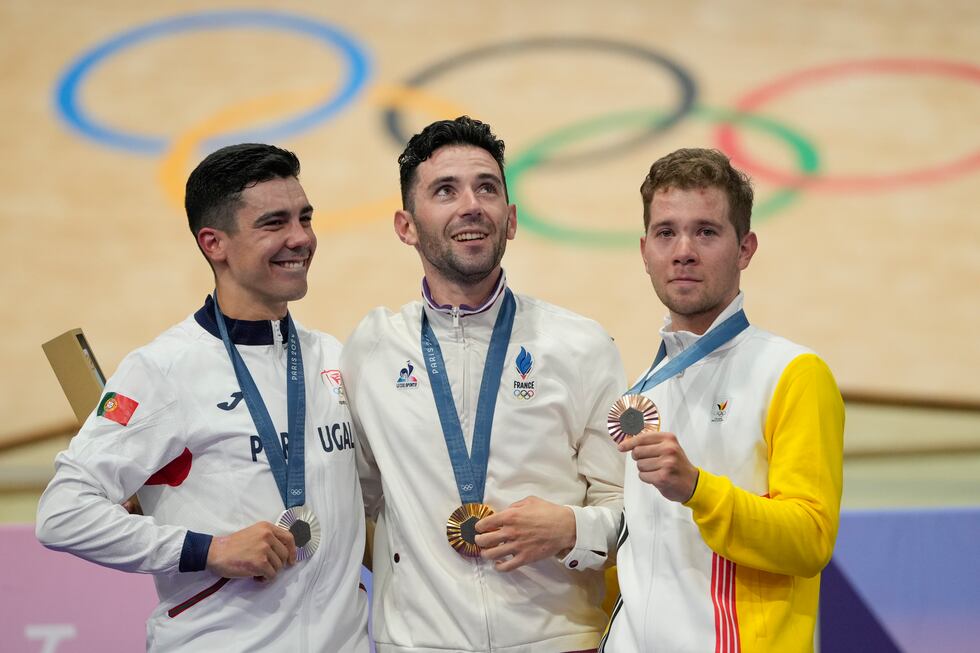 Benjamin Thomas of France, centre, winner of the gold medal of the men's omnium event, stands...