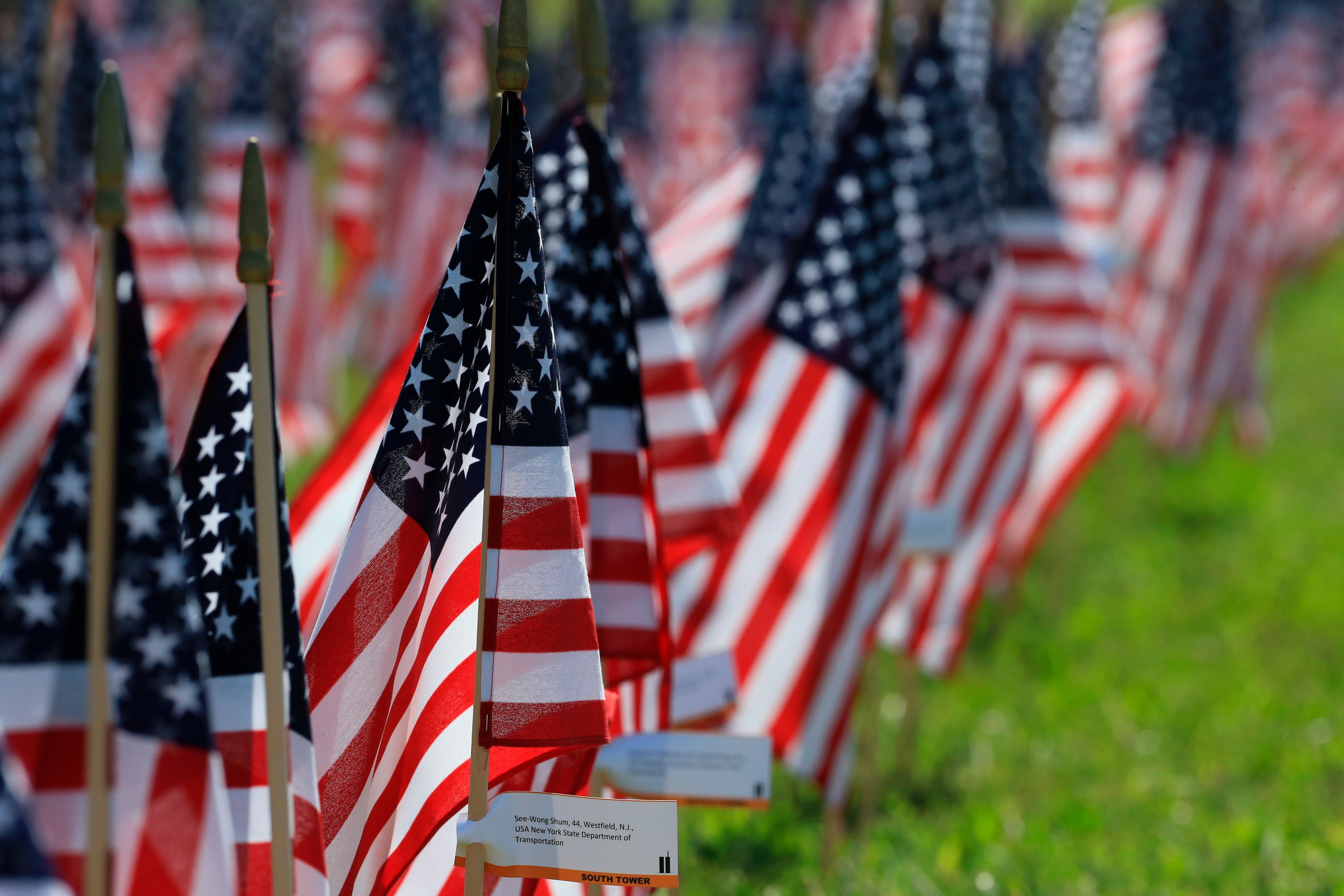 Flags bearing the names of victims of the 9/11 attacks stand in Memorial Park in Omaha, Neb.,...