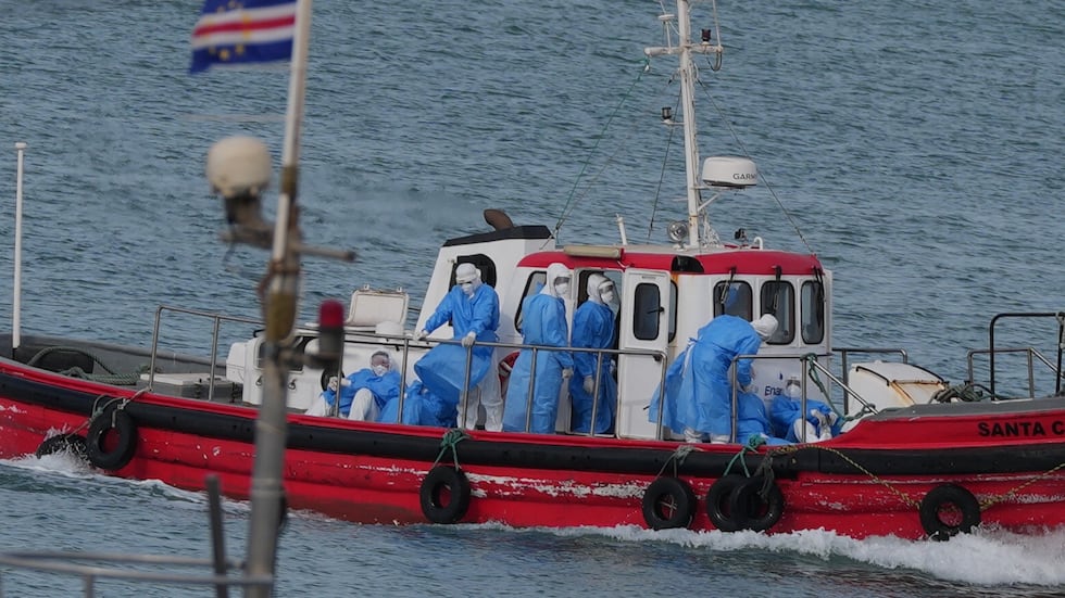 Health workers in protective gear arrive to evacuate patients from the MV Hondius cruise ship...