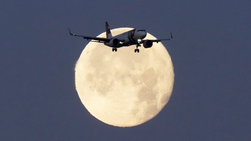 FILE - A TAP Air Portugal Airbus A320 is silhouetted against the setting moon while...