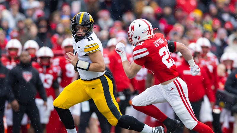 Iowa quarterback Mark Gronowski (11) rushes against Nebraska defensive back Rex Guthrie (21)...