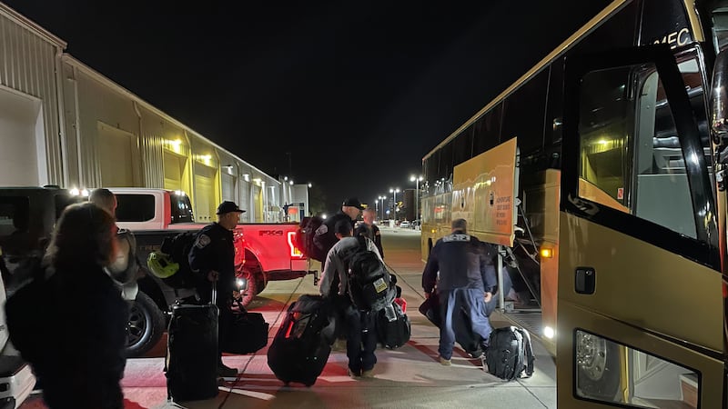 Members of Nebraska Task Force 1 load up a charter bus as they head to the southeastern U.S....